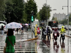 北京早高峰遭遇降雨 市民撑伞出行