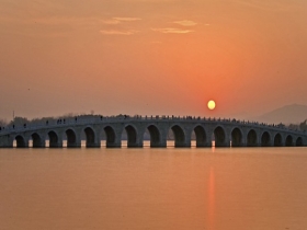 北京颐和园落日余晖水天一色 十七孔桥仿若天地分界线