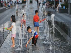 北京高温炙烤下 孩童喷泉戏水享清凉