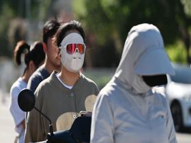 北京开启晴晒模式 街头市民忙防晒