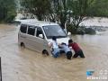 图为广西河池市罗城仫佬族自治县宝坛乡寨芹村一处低洼路段，一辆微型车在水中抛锚。（新华网发 廖光福摄）