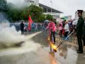 今天是消防日，参加消防宣传活动的市民正在学习灭火器的使用。（摄影：李斌喜）