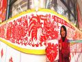 近日在南宁国际会展中心大厅内，一幅10米长的鸡年主题剪纸长卷亮相，引起关注。这是曾多次获全国大奖的民间工艺师钟昀睿的作品，她前后花了1个月时间设计、调整和剪纸，终于将这幅长卷呈现在市民面前。记者 徐天保 摄（广西新闻网-当代生活报）