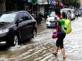鹿寨县城道路积水严重，家长背孩子上学（摄影：黄金石）