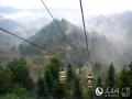 5月19日，游客在广西龙胜龙脊镇大寨村乘坐缆车观赏美景。