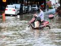 田东县城广场一带发生内涝，电动车涉水而过。（摄影：戴雨菡）