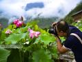 6月15日，游客在广西桂林市龙胜各族自治县泗水乡周家村白面瑶寨观赏荷花。（摄影：潘志祥）