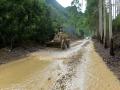 遂意到忻城一路段洪水冲垮山坡导致路面泥沙堆积，2日下午16时左右，铲车正在清理路面堆积物。（摄影：刘国平）