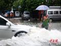 8月3日，广西北海市突降暴雨，市区多处路段出现内涝，民众出行受阻。当地交警、城市排水设施管理处等相关部门深入各内涝、堵点进行疏导或指挥，全力应对暴雨对民众出行造成的影响。（摄影：钟欣）