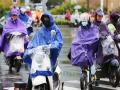今天南宁雨雾蒙蒙，骑车市民披着雨衣出行。（摄影：刘英轶）