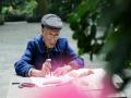 市民在茶花苑里悠闲自得地练习书法（摄影：刘英轶）