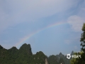 中国天气网广西站讯 22日，平乐县午后一阵雷雨后，在天空灰白相间的地方，出现了淡淡的七色彩虹，过了一会，彩虹的颜色更艳了，就像一条美丽的七彩桥横跨天空，引得人们驻足拍照欣赏，让人雨后的心情像彩虹色彩一样，绚烂起来。（文/莫泳 图/何建坤）