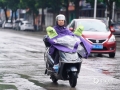 图为14日早上，钦州市民在雨中骑车出行。（图/李斌喜）
