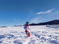 图为小女孩在雪地里开心地玩雪。