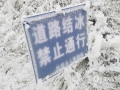 图为12月17日，融水县杆洞乡护鸟坳路段道路结冰，禁止通行的指示牌也被冰雪覆盖。（图/罗悦）