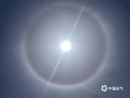 中国天气网广西站讯 今天（14日）广西南宁、桂林、玉林等市多地天空上出现了日晕。日晕是由于悬浮在大气中的冰晶把太阳光或月光折射或反射而形成的光学现象。当光线射入卷层云中的冰晶后，经过两次折射，分散成不同方向的各色光。图为的桂林市平乐县上空的日晕。（图/李红 文/周玉）