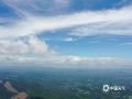 中国天气网广西站讯 6月24日，防城港十万大山顶，云端之上，群山如墨色浪涛翻涌。天光透过云层缝隙洒落，明暗交织间，山河壮阔尽显，仿佛时间在此刻凝固，只剩自然的诗意在天地间流淌。（图文/白玉壮）
