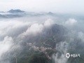 中国天气网讯 随着近几日降雨频繁，湿度增大，河北唐山遵化山区的清晨出现了罕见的云雾景观。通过无人机的高空拍摄可以看到，云雾飘荡在天空犹如大海一般，山村、山峰和庙宇在其中若隐若现，美如仙境。无人机拍摄（图/刘满仓）