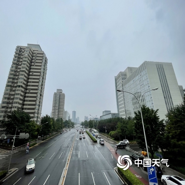 北京出现降雨 路面被打湿行人撑伞